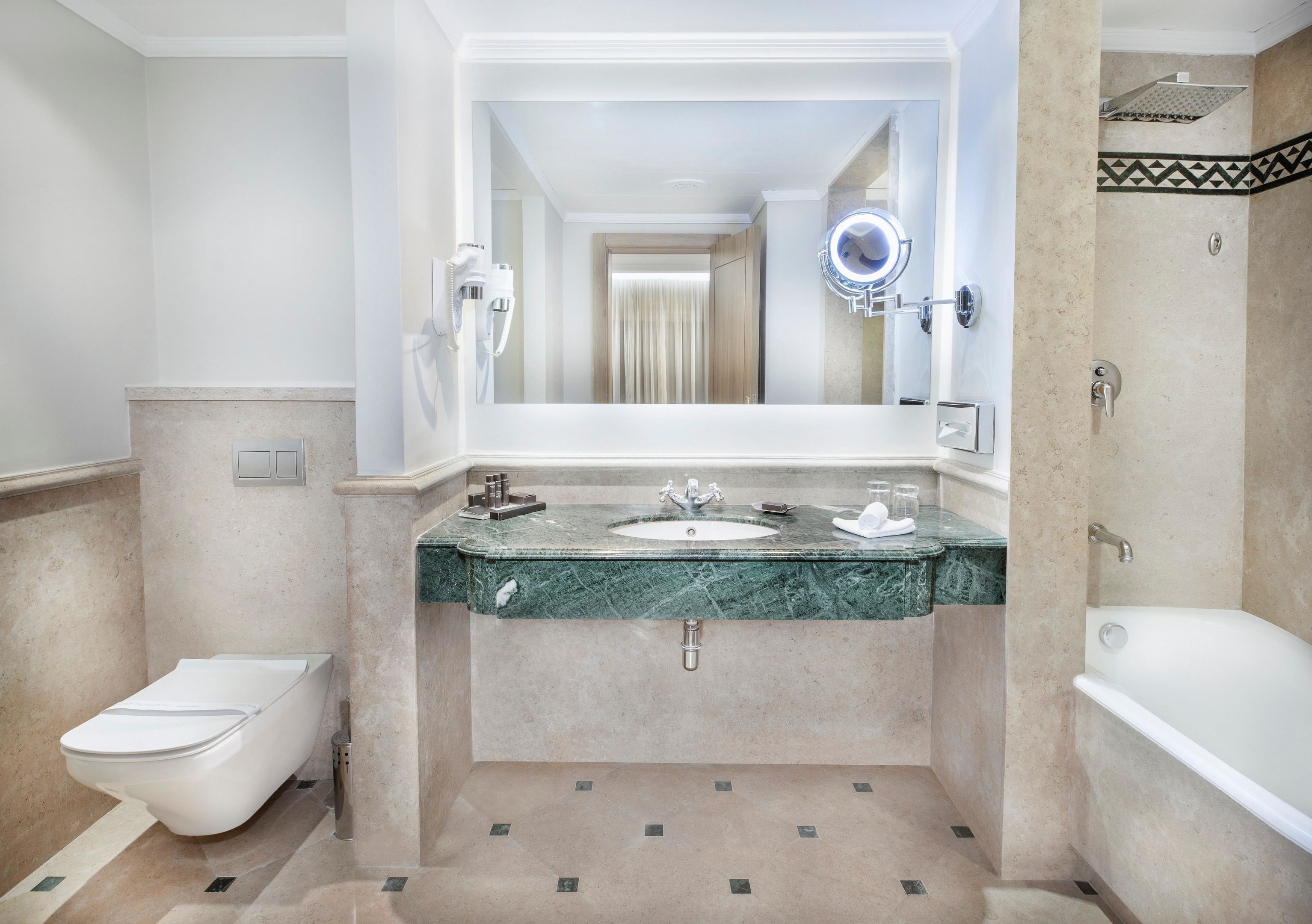 A bathroom with a marble sink, a toilet, and a bathtub.