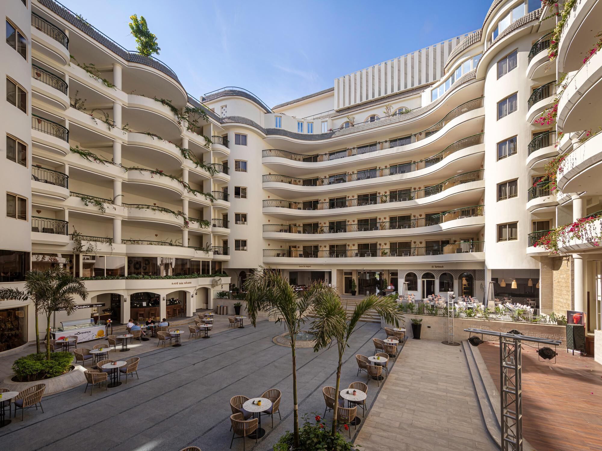 A multi-story hotel with outdoor seating areas and balconies.