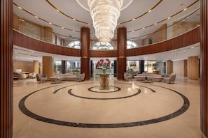 A spacious lobby with a central circular design, large wooden columns, and a chandelier. - Steigenberger Nile Palace (Luxor)