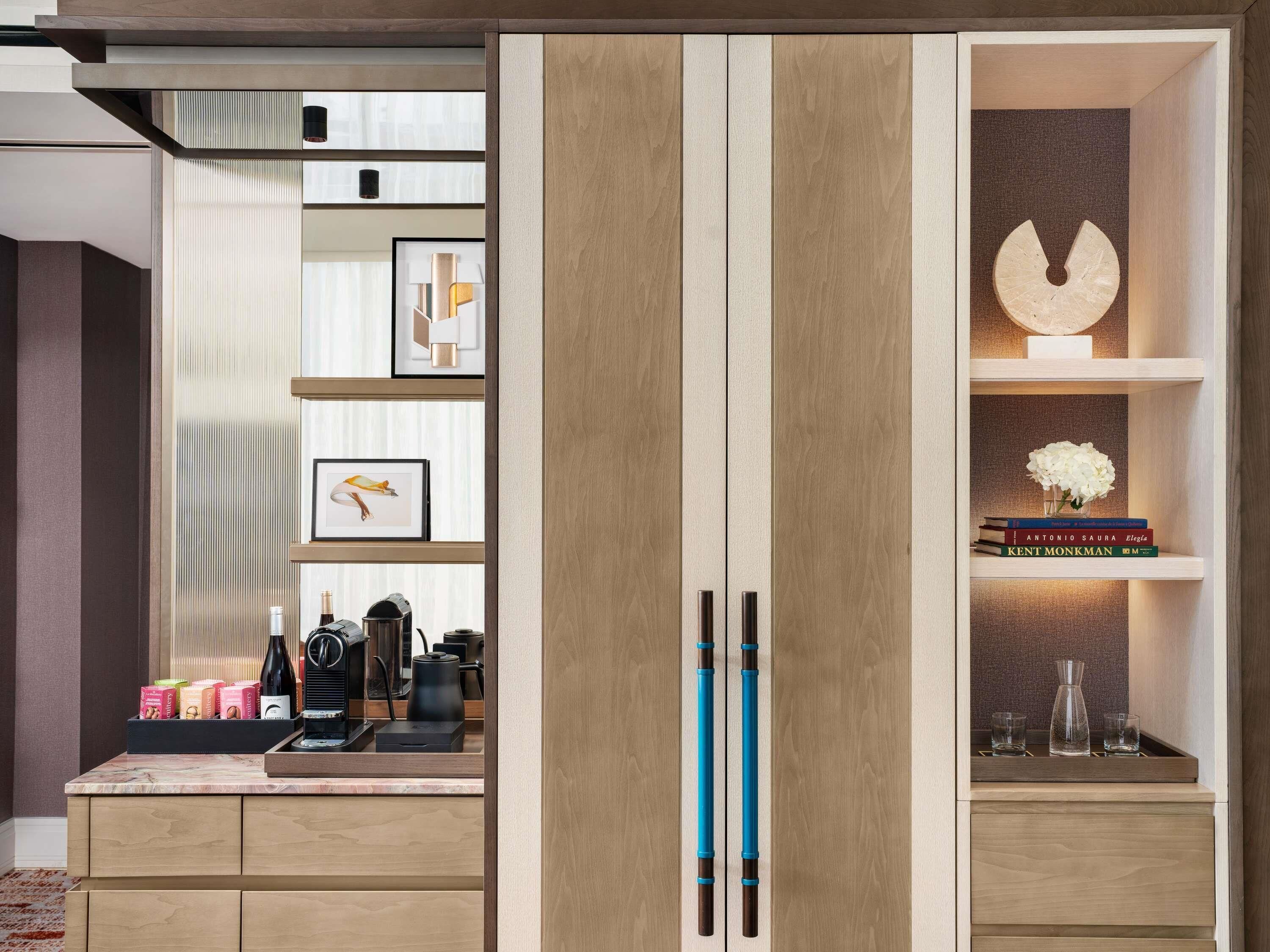 A modern kitchen with wooden cabinets, a coffee machine, and a coffee press.