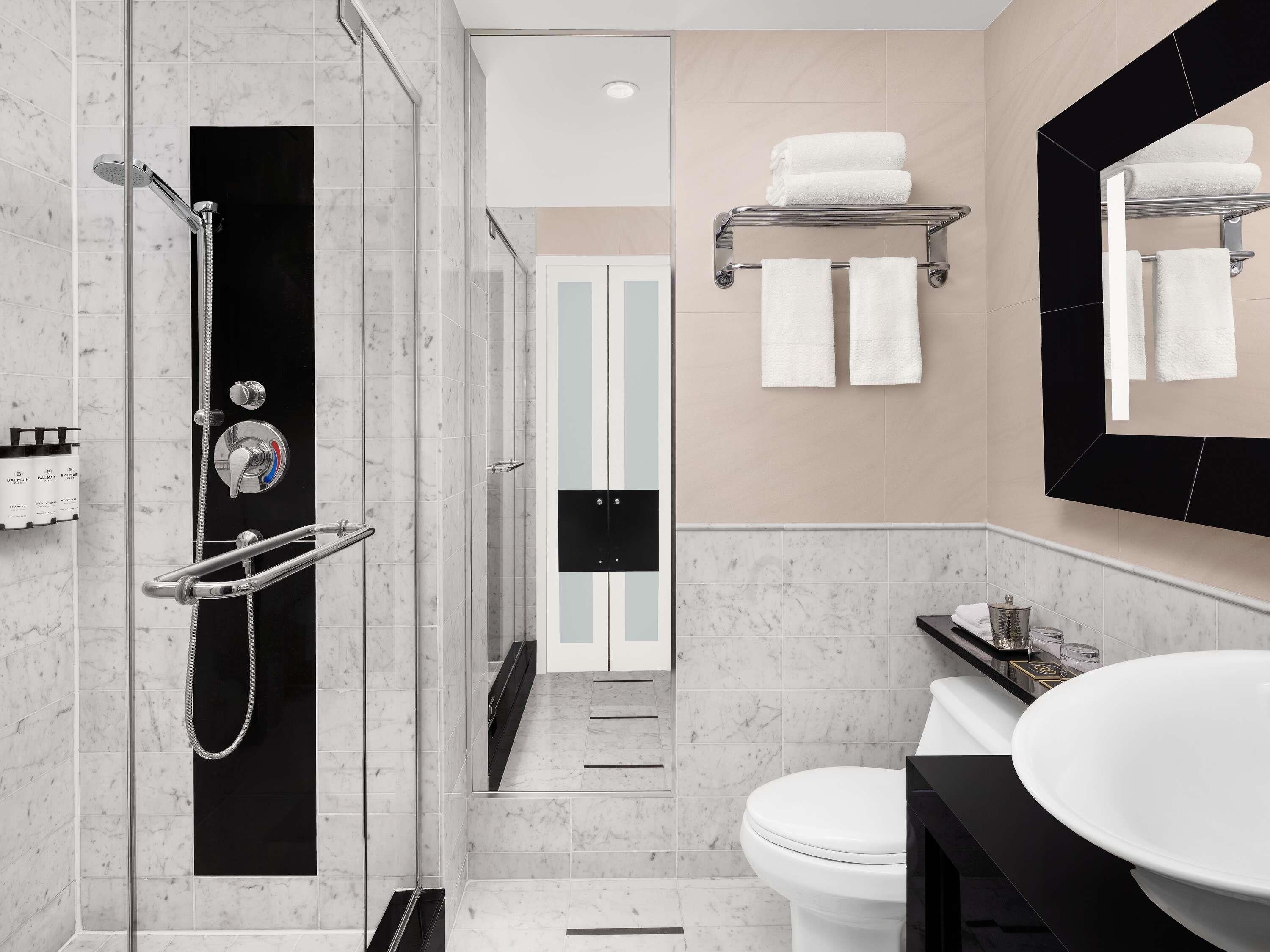 Un baño moderno con cabina de ducha, inodoro y lavamanos.