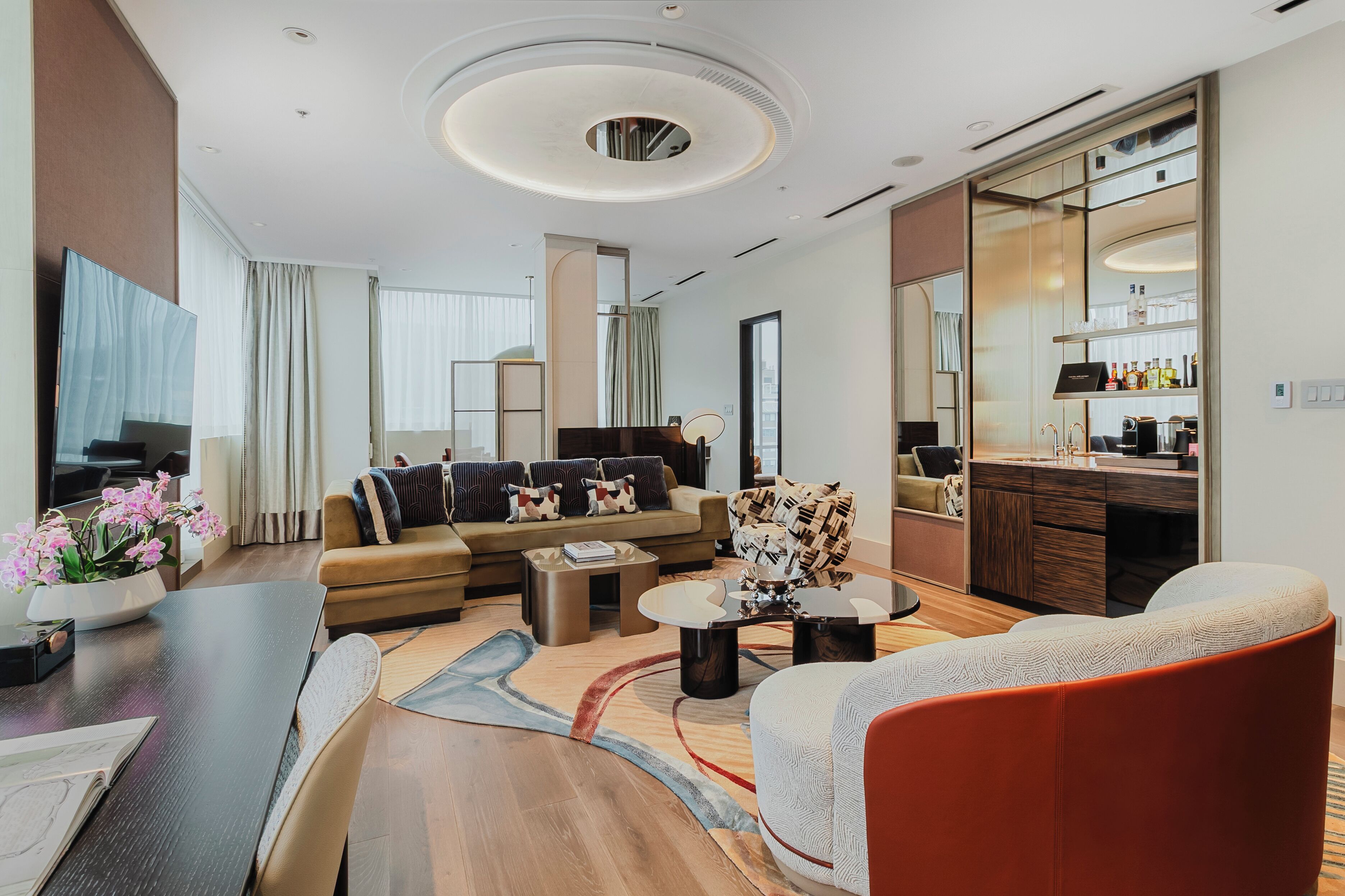 A modern living room with a sofa, coffee table, and a dining area.