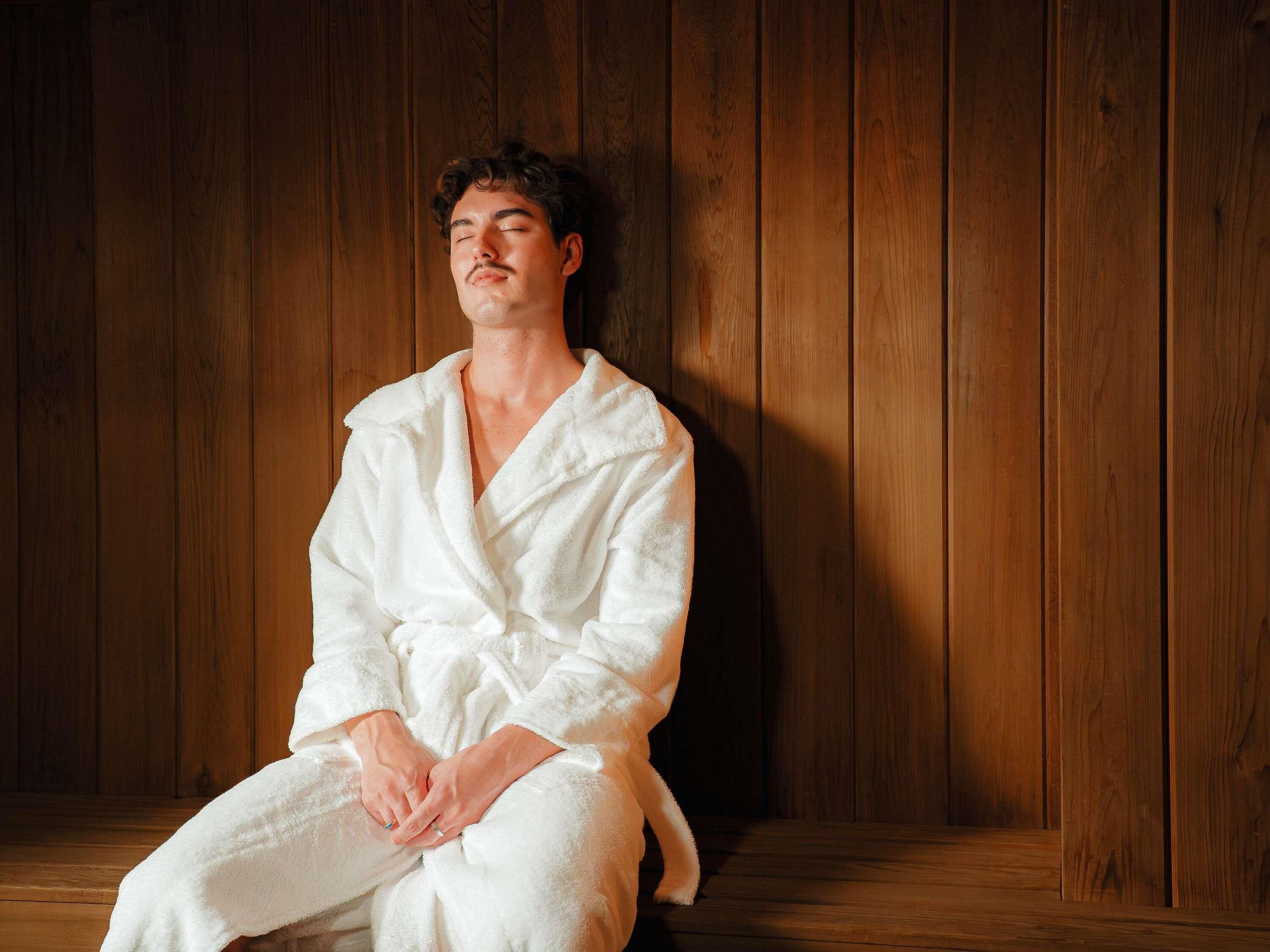 A person sitting in a room with wooden paneling.