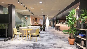 Ein modernes Interieur mit einer Sitzecke, einer Rezeption und Blumentöpfen.