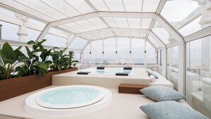 Un área de spa moderna con hidromasaje, asientos y plantas.