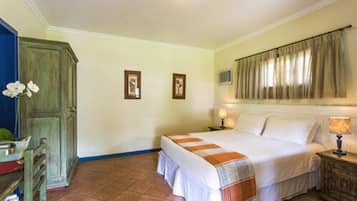 Un dormitorio con cama, mesita de noche, cómoda y ventana con cortinas.