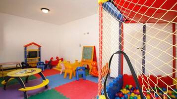Children can play safely in this play area with a playpen, slide, and climbing frame.