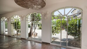 A spacious interior with large arched windows, a marble floor, and a patterned ceiling. - iH Hotels Agrigento Kaos Resort (Agrigento)