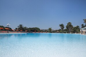 Alberca al aire libre, sombrillas en la alberca y camastros 