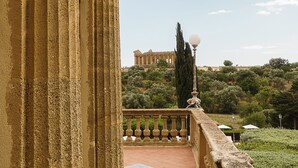 Eine Steinschilderkanzel mit Blick auf einen Garten und eine entfernte Ansicht eines klassizistischen Gebäudes.