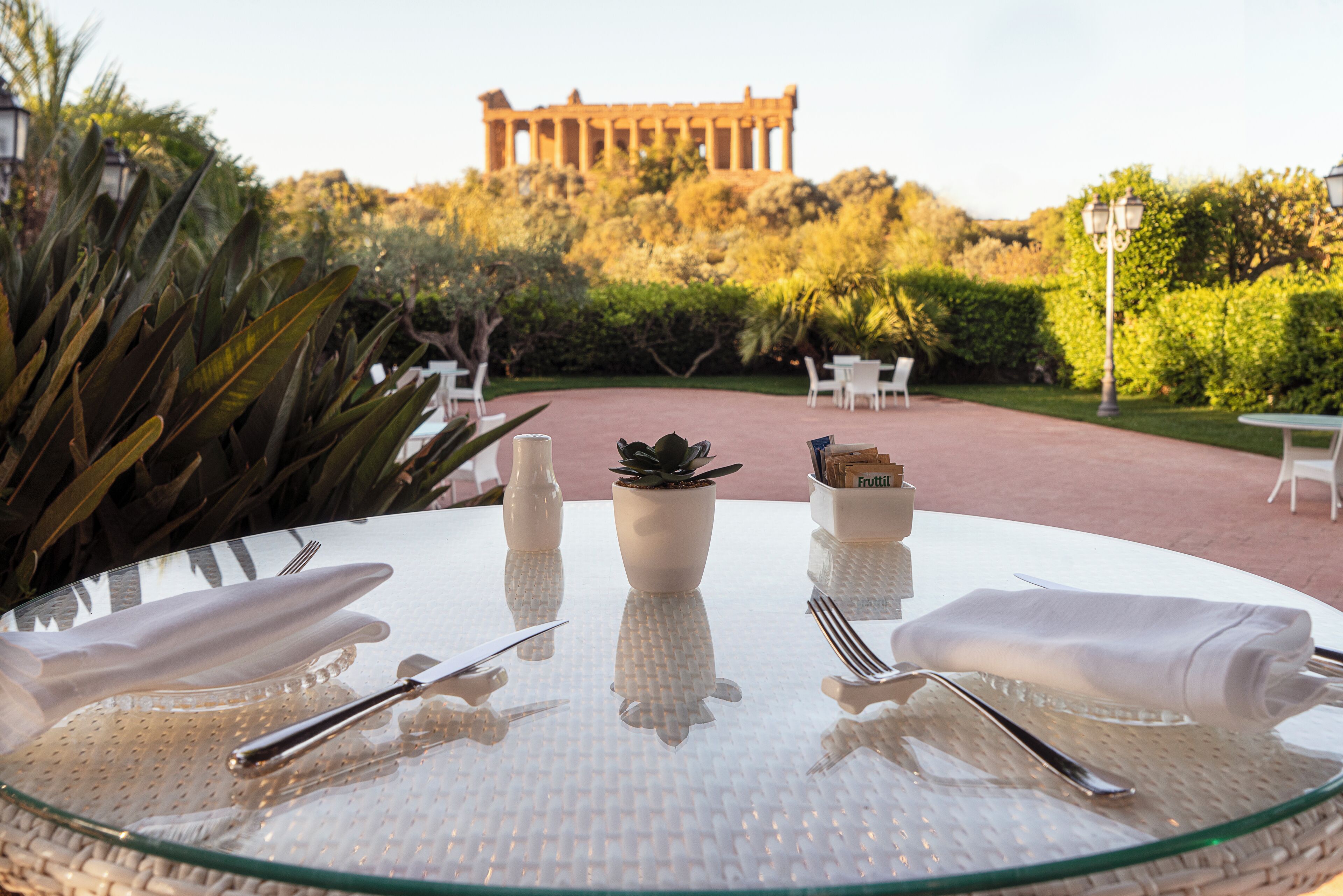 Une table dressée pour le dîner, avec en arrière-plan la vue d’un ancien temple.