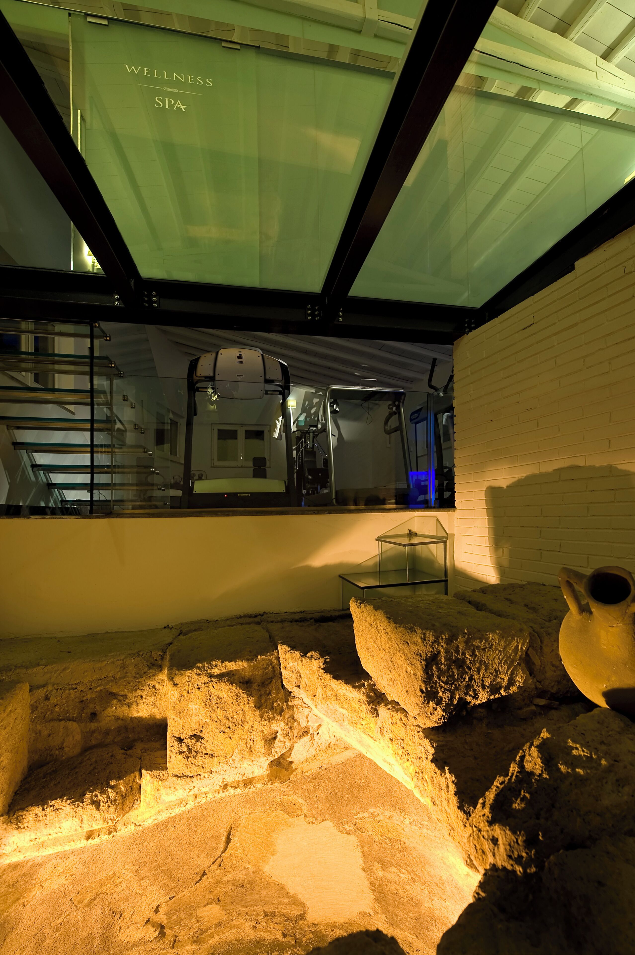 A spa area with a glass ceiling, a bed, and a small table.