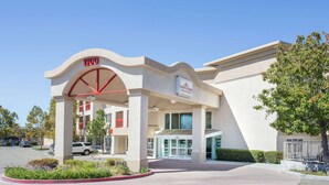 A modern hotel entrance with a clear sky, a 1700 sign, and a gated driveway. - Hawthorn Suites by Wyndham Livermore Wine Country (Livermore)