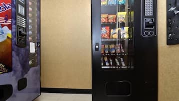 A vending machine with snacks and a Coca-Cola machine.