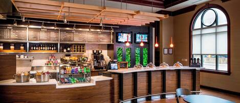 A modern bar area with wooden accents, a menu board, and a large window.