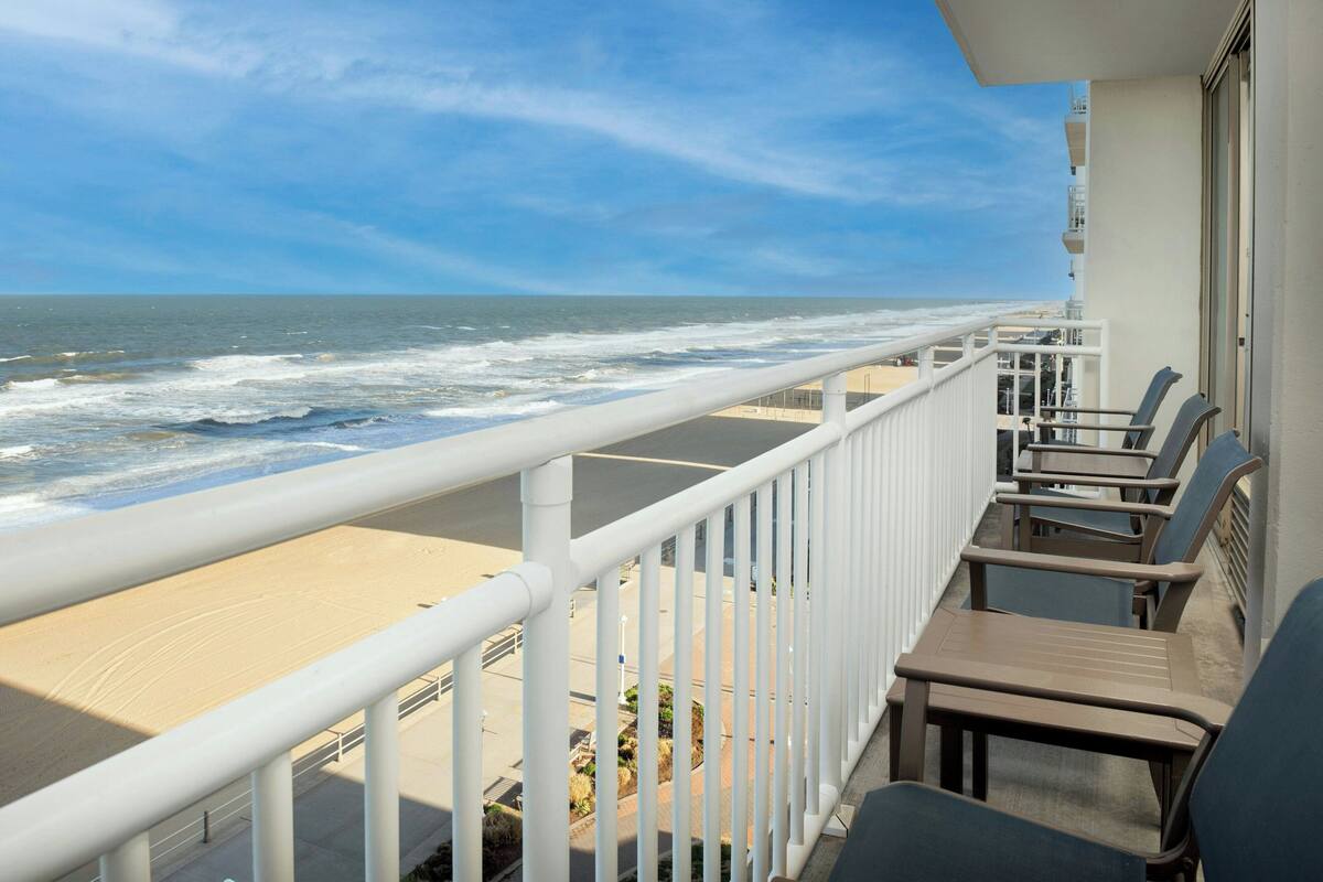 A balcony with a view of the ocean and beach.