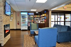 A lobby with seating, a refrigerator, and a fire extinguisher. - Comfort Suites Northside Hospital Gwinnett (Lawrenceville)