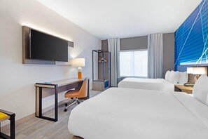 A hotel room with a bed, a desk, a chair, a TV, a wardrobe, and a window with curtains. - Comfort Suites Northside Hospital Gwinnett (Lawrenceville)