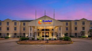 A Comfort Suites hotel entrance with a covered lobby, multiple floors, and a landscaped front area. - Comfort Suites Port Allen - Baton Rouge (Port Allen)