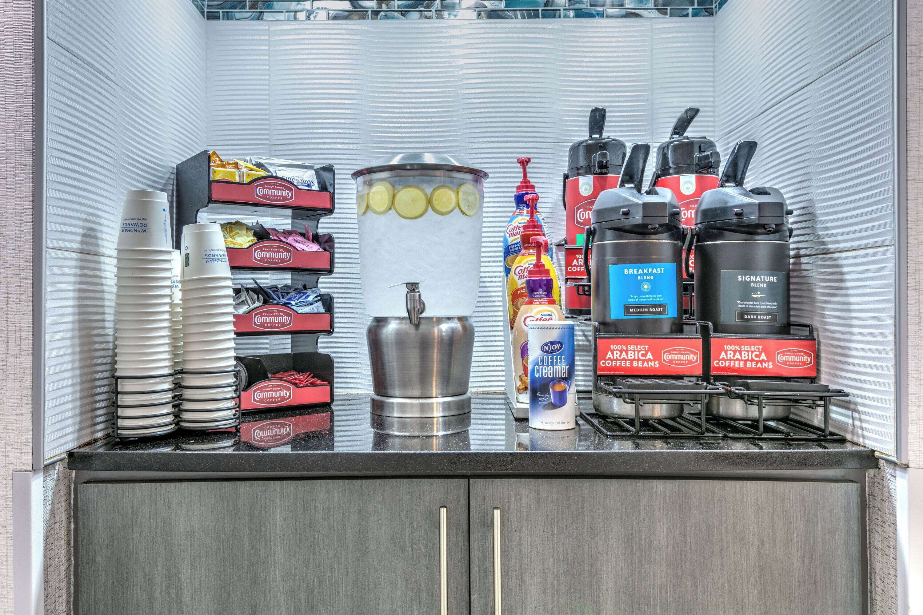 A coffee station with coffee beans, creamer, and a coffee machine.