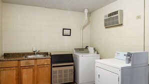 Une buanderie équipée d’un évier, d’un sèche-linge et d’une machine à laver.
