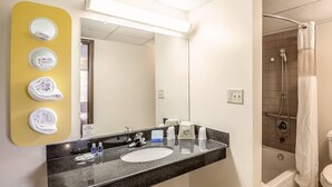 Une salle de bain équipée d’un lavabo, d’un miroir et d’un porte-serviettes.