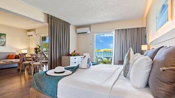 Una habitación de hotel con una cama grande, un escritorio, un sofá y un balcón con vistas.