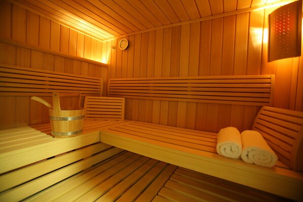 A wooden sauna with benches and a bucket. - Clayton Hotel Limerick (Limerick)