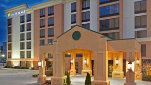 Ein mehrstöckiges Hotel mit markantem Eingang, großen Fenstern und einer gut beleuchteten Fassade.