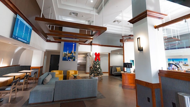 Eine moderne Lobby mit Empfangsschalter, Sitzbereich und einem geschmückten Weihnachtsbaum.