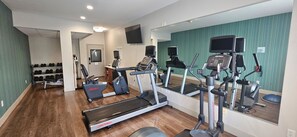A home gym with treadmills, an elliptical, and a weight bench. - Holiday Inn Express Greensburg by IHG (Greensburg)