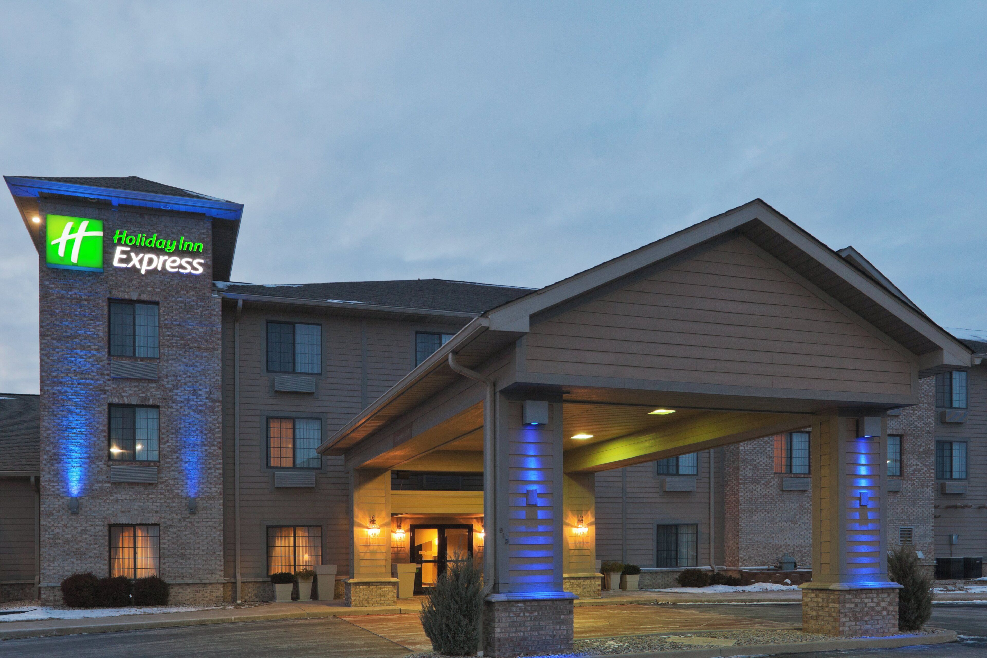A Holiday Inn Express building with a brick facade, a covered entrance, and a sign with the hotel name.