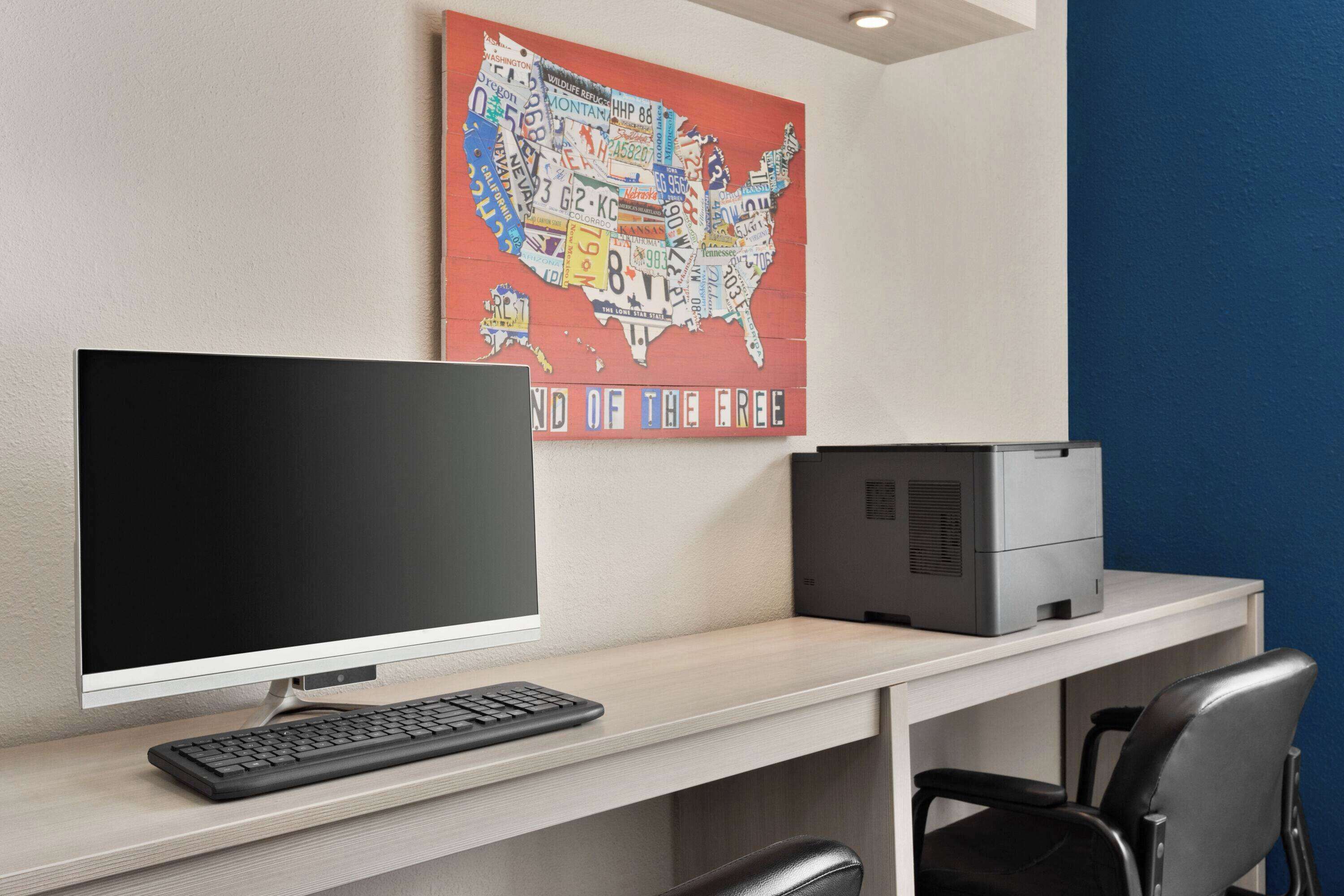 A modern office desk with a computer, a printer, and a chair.