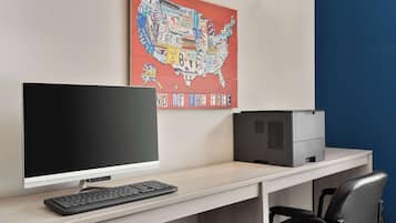 A modern office desk with a computer, a printer, and a chair.