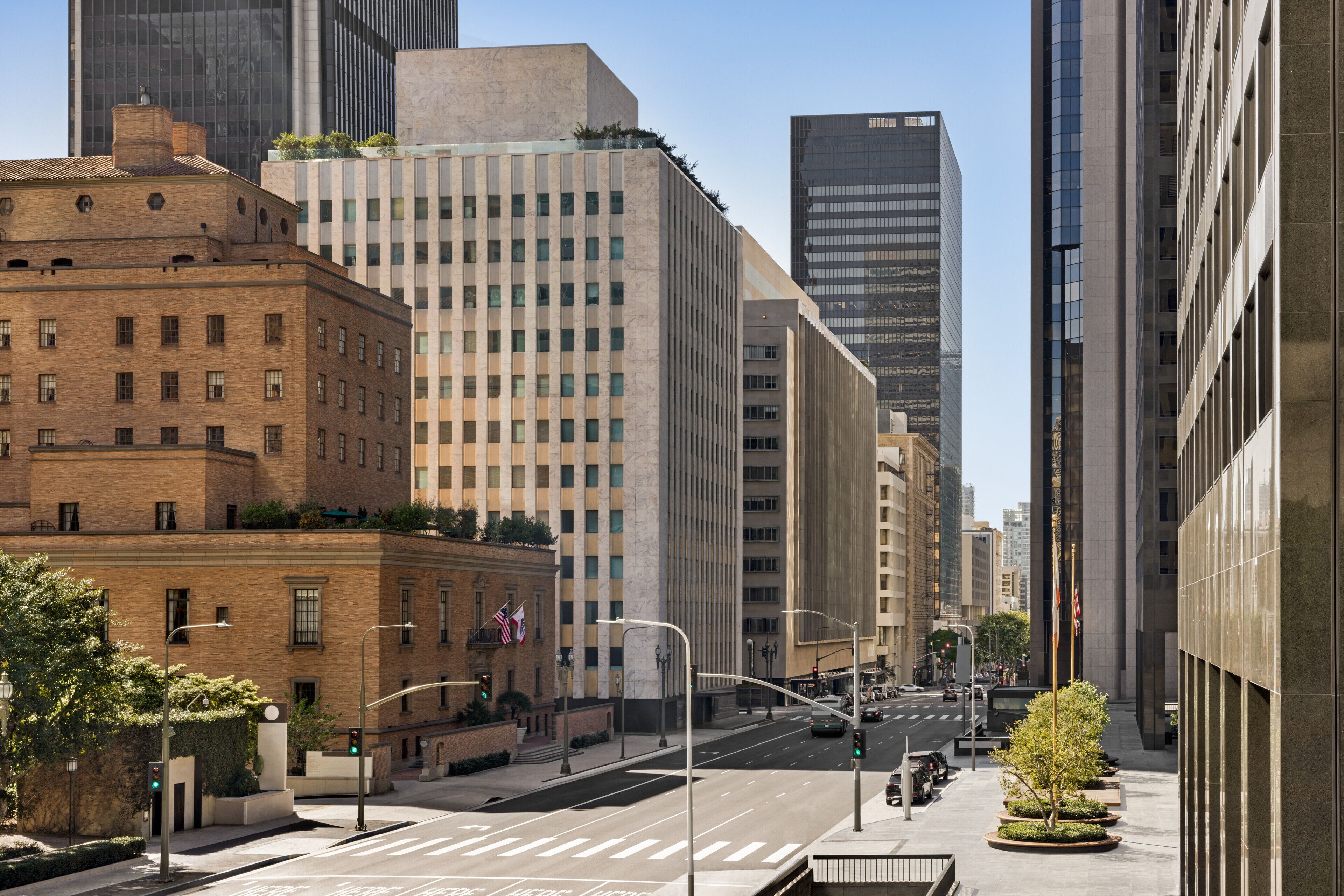 A city street lined with tall buildings, including a mix of modern and older architecture.