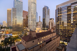 A cityscape with modern high-rise buildings and a historic brick building with a flat roof.