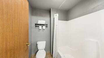 A bathroom with a toilet, a shower, and a towel rack.