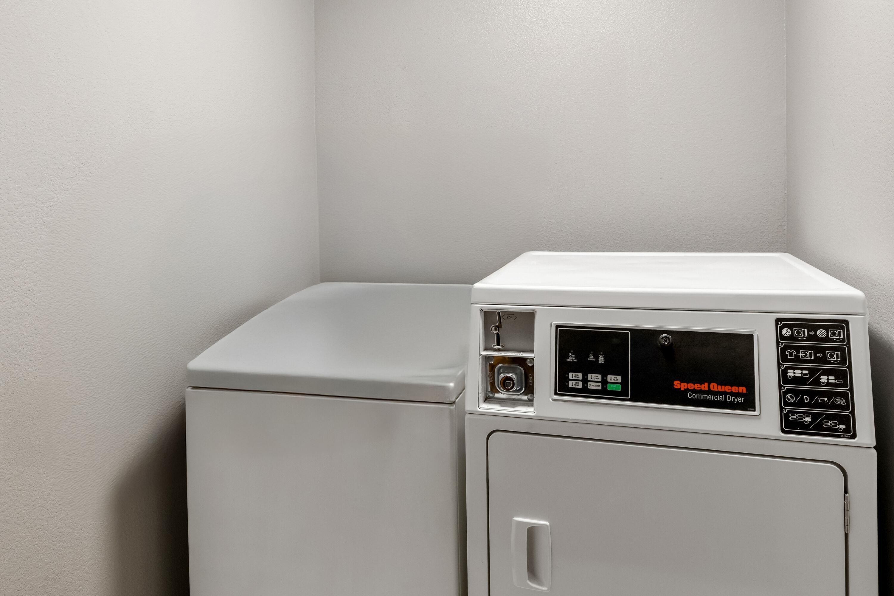 A commercial dryer with a control panel, a door, and a handle.