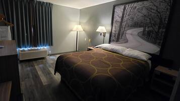 Une chambre d’hôtel avec un lit, deux lampes de chevet, un téléphone fixé au mur, une grande fenêtre avec des rideaux et un tableau représentant une route sinueuse.