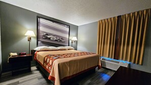 A hotel room with a bed, nightstands, a wall clock, a lamp, and a window with curtains.