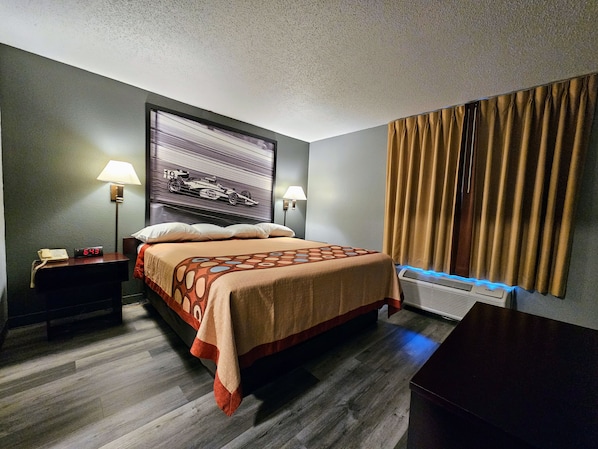 A hotel room with a bed, nightstands, a wall clock, a lamp, and a window with curtains. - Super 8 by Wyndham Cloverdale IN (Cloverdale)