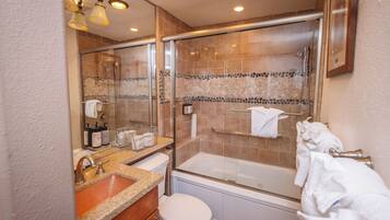 Une salle de bain moderne avec une douche à parois de verre, une baignoire, un lavabo avec un meuble-vasque et des toilettes.