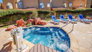 Una piscina con sillas de descanso y un puesto de salvavidas.