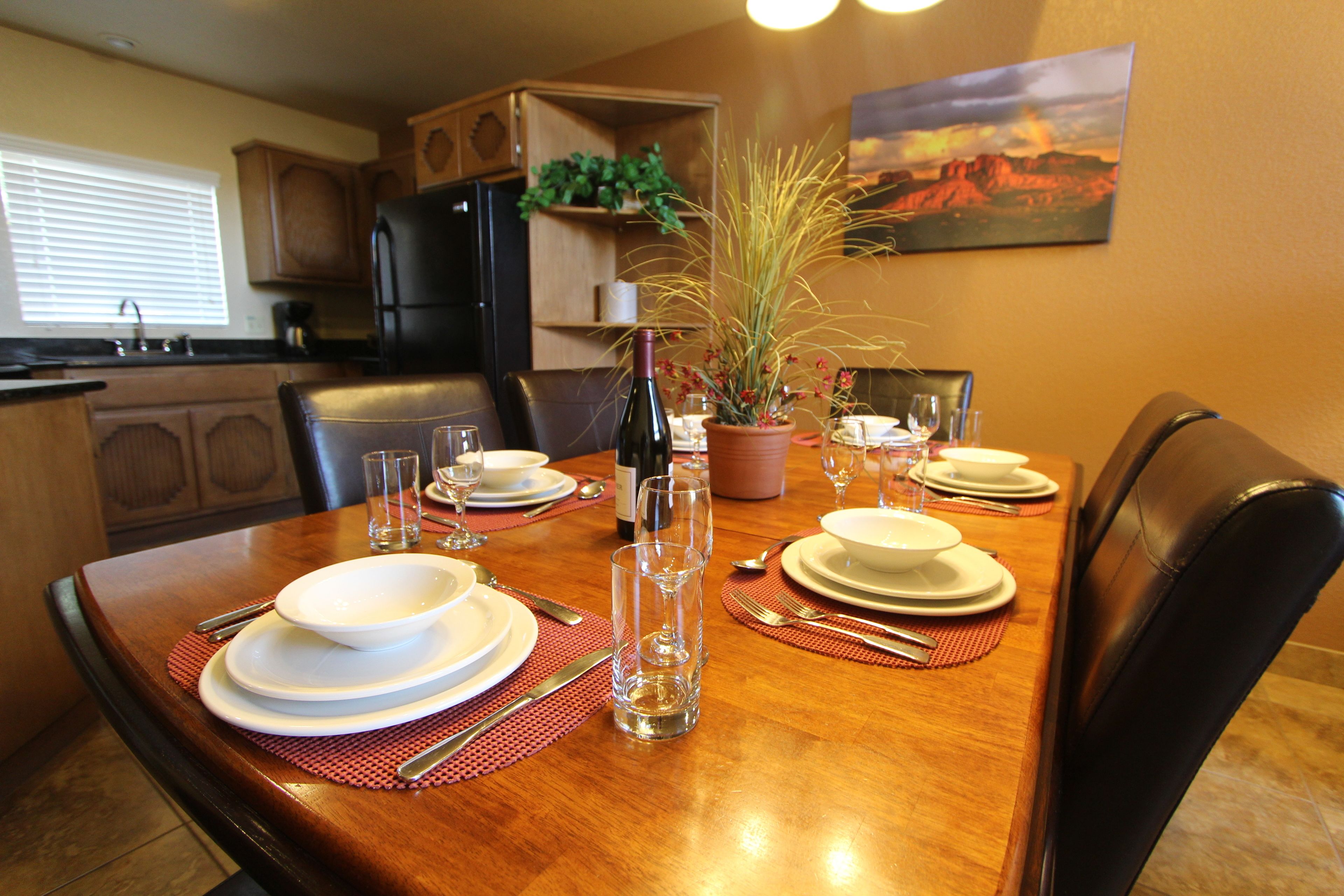 A dining table set for six with plates, glasses, and cutlery.