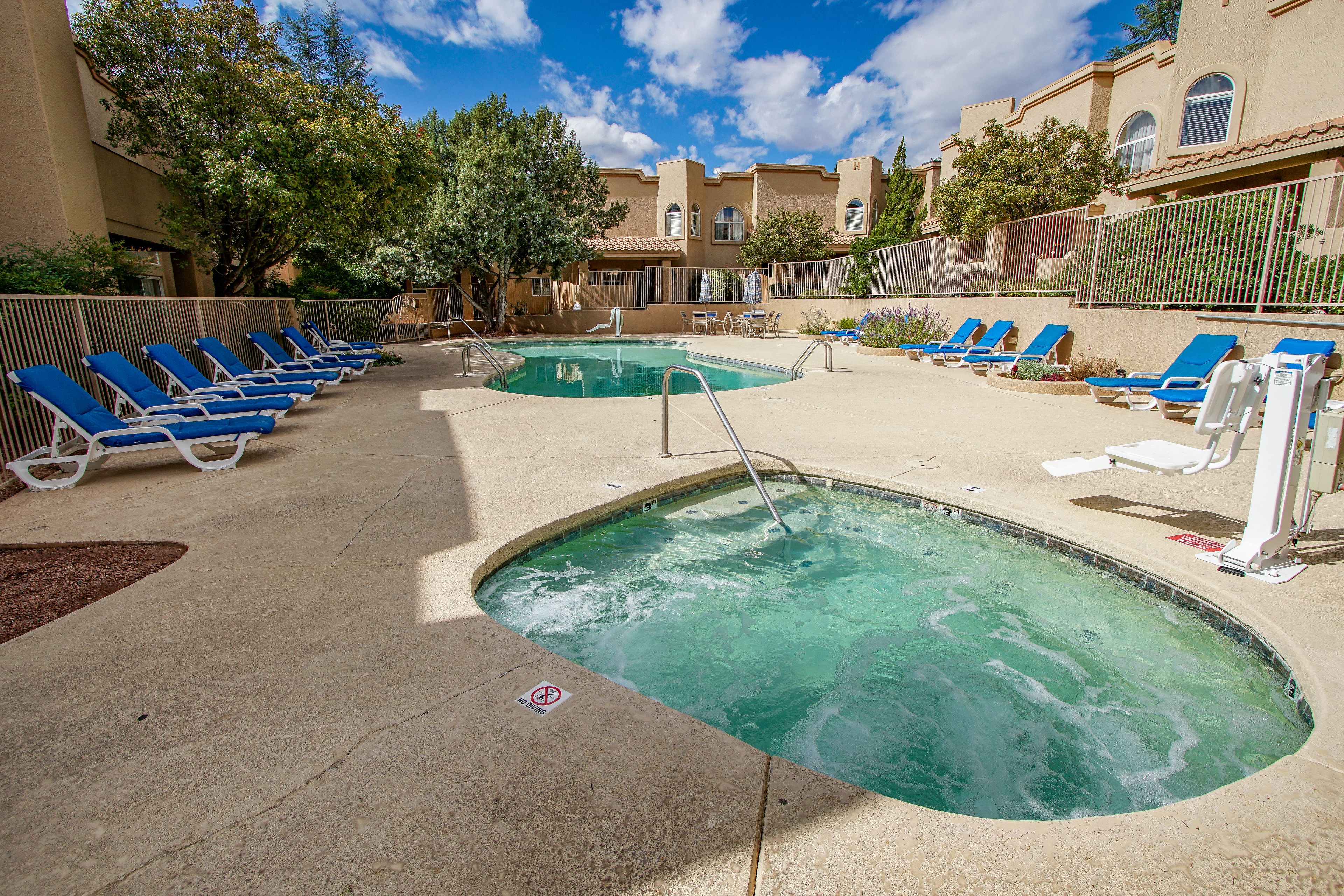 A pool area with multiple lounge chairs and a small pool.