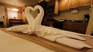 Una cama con una toalla doblada en forma de cisne y corazón.