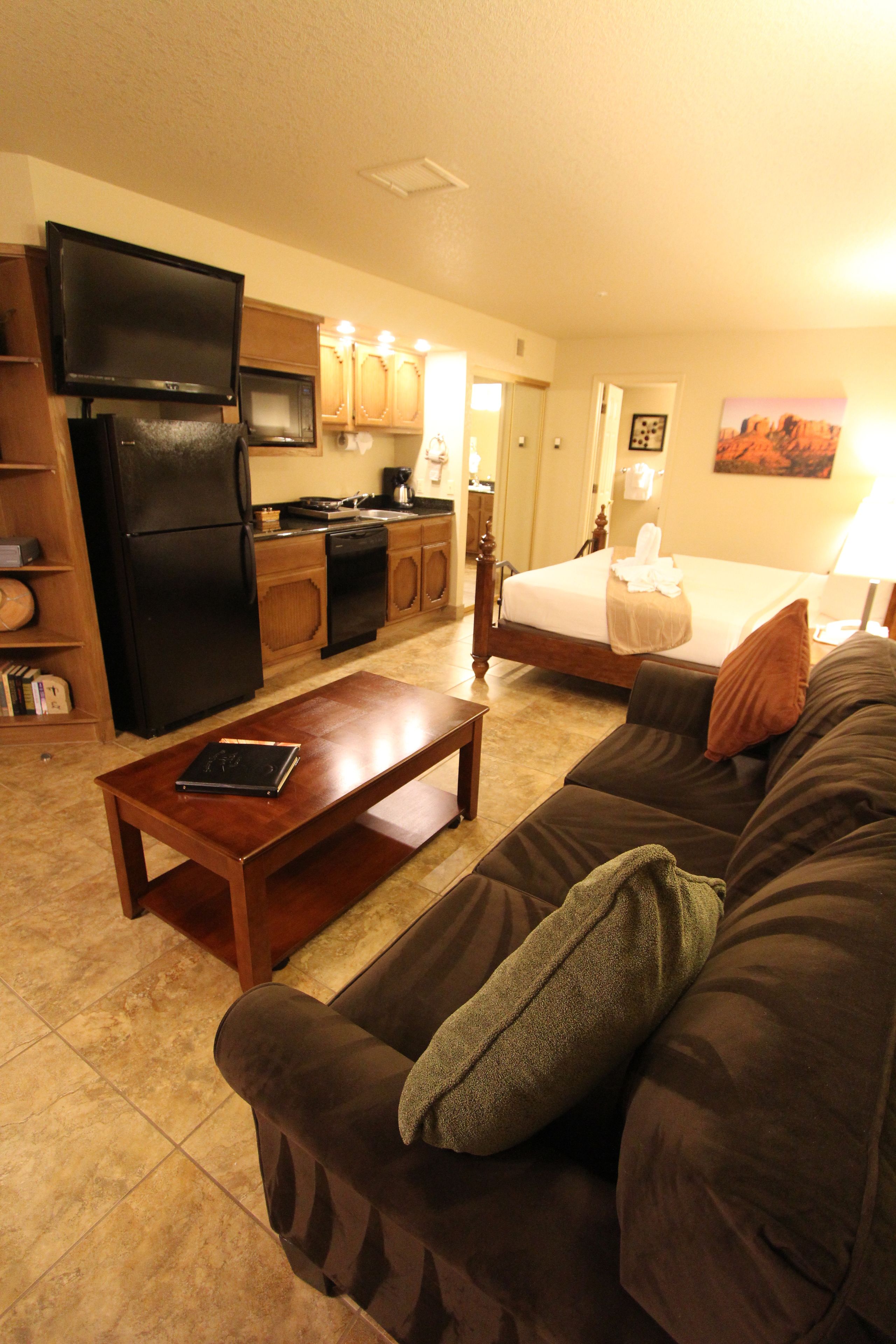 A compact living space with a kitchenette, a bed, a sofa, and a coffee table.