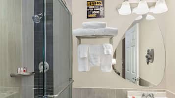 A modern bathroom with a glass shower enclosure, a white sink, and a large mirror.