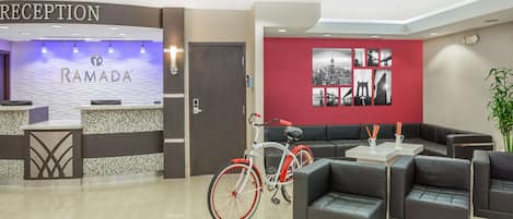 A reception area with a reception desk, a bicycle, and seating arrangements.