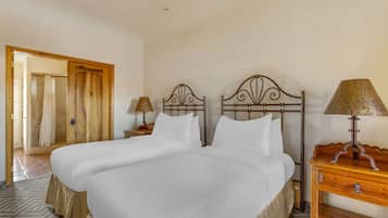 A double bed with a wooden headboard, a nightstand with a lamp, and a wooden dresser.